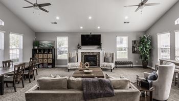 A living room with a grey couch and a fireplace.